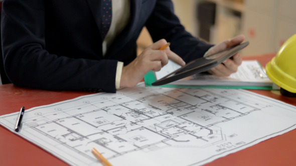 Engineers Using Tablet Blueprint in Background Engineers Using Tablet Blueprint in Background