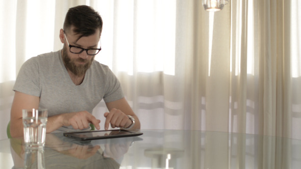 Young Man Typing on Tablet Young Man Typing on Tablet