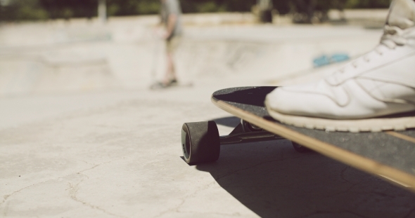Man Standing With One Foot On a Skateboard alt