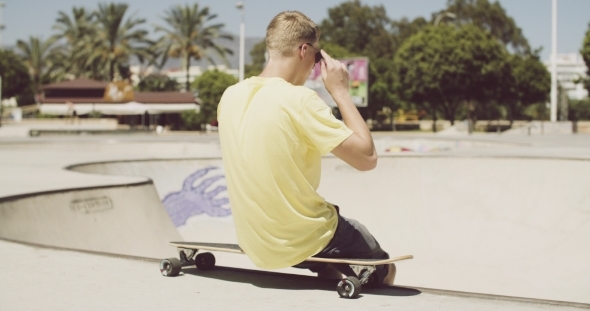 Boy At The Skate Park Putting On Sunglasses Boy At The Skate Park Putting On Sunglasses