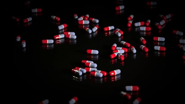Pills Capsules Falling Onto Black Glass 1