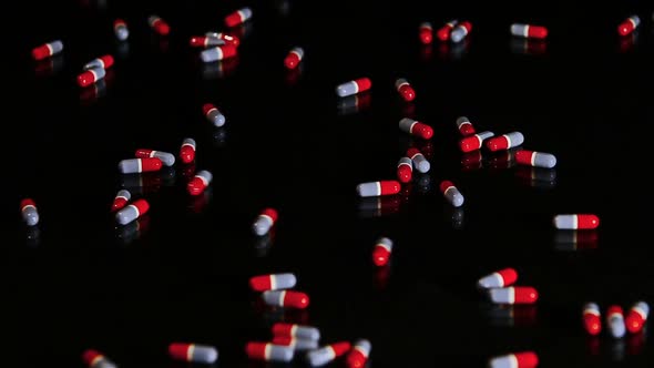 Pills Capsules Sliding On Black Glass - Isolated 1