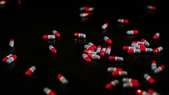 Pills Capsules Sliding On Black Glass - Isolated 2