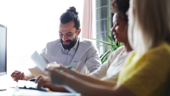Happy Creative Team With Papers Talking In Office 1 alt