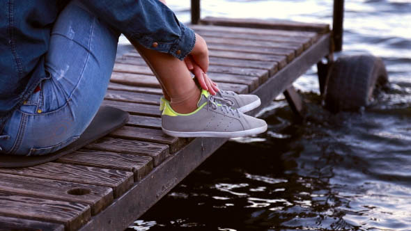 Girl Sitting on a Pier Looking at the Waves Girl Sitting on a Pier Looking at the Waves