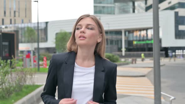 Serious Businesswoman Walking on the Street While Looking Around alt