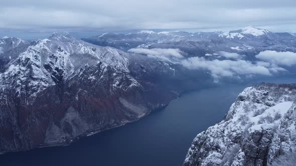 Hiker with backpack standing on mountain waving at Lake Como, Italy alt
