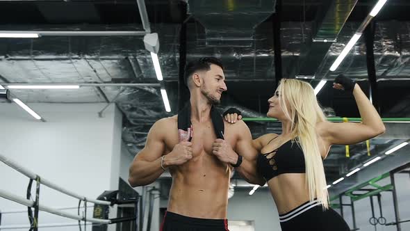 Attractive Sport Couple Man and Woman Possing on the Gym Background alt