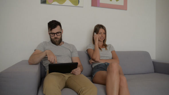 Man Using Tablet Girl Talking on Smartphone Man Using Tablet Girl Talking on Smartphone