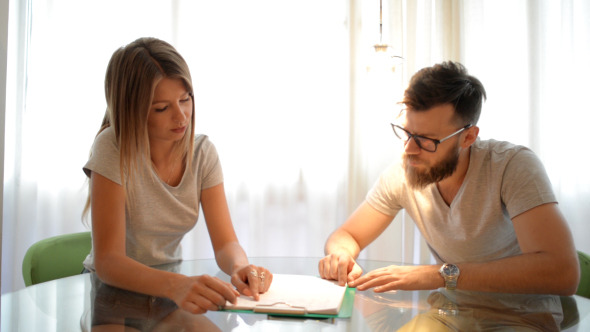 Couple Reading and Discussing documents Couple Reading and Discussing documents