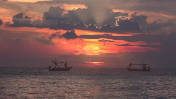 Fishing boats on an ocean at sunrise.