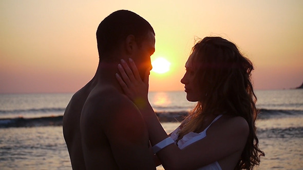 Portrait Of Ethnic Couple Kissing On The Beach
