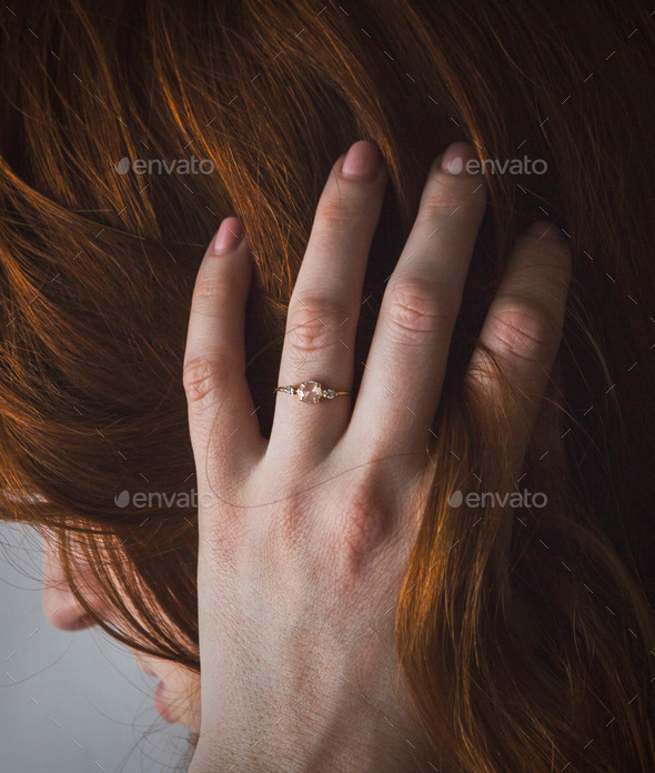 Woman with Ring on Hand Running Hand Through Her Hair