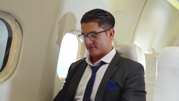 Young Businessman Using Laptop Computer in Airplane alt