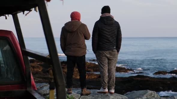 Slow motion: friends look at the sea and chat as they prepare to go fishing and spearfishing during alt