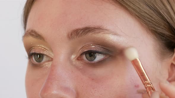 Beautiful Shiny Shadows are Applied with a Special Brush on the Eyelid of the Model alt