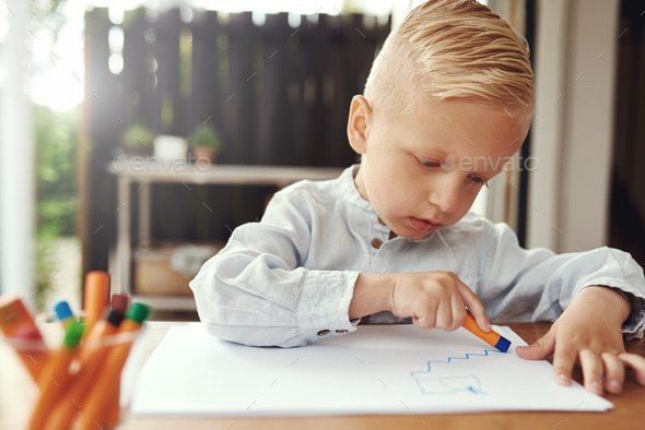 Handsome young boy drawing with crayons - Stock Photo - Images
