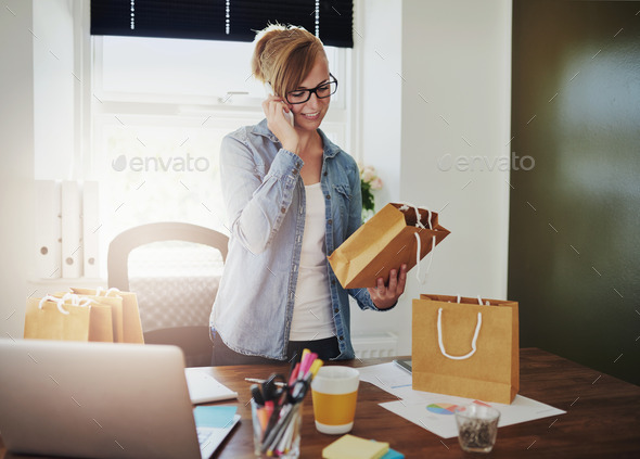 Motivated businesswoman placing orders on a phone - Stock Photo - Images