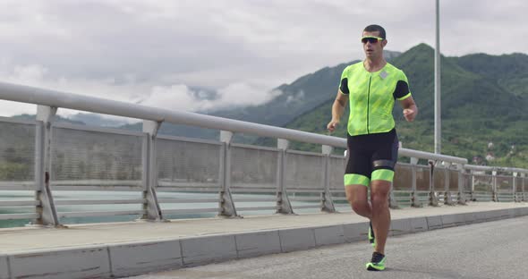 Triathlon  Male Triathlete Running in Triathlon Suit Training for Ironman Race alt