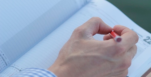 Man Writes In Notebook alt