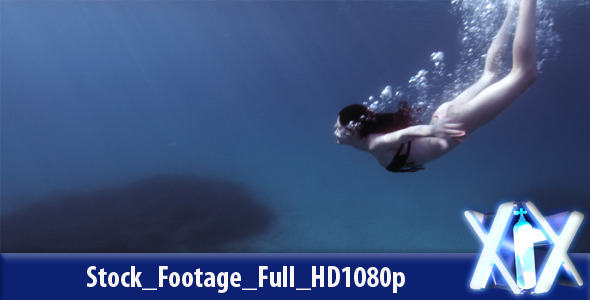 Woman Swimming Underwater In The Blue Sea