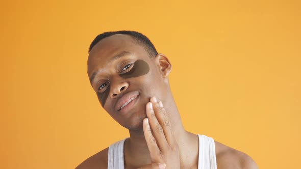 a Serious Young AfricanAmerican with Cosmetic Patches Under His Eyes Cosmetic Procedures on an