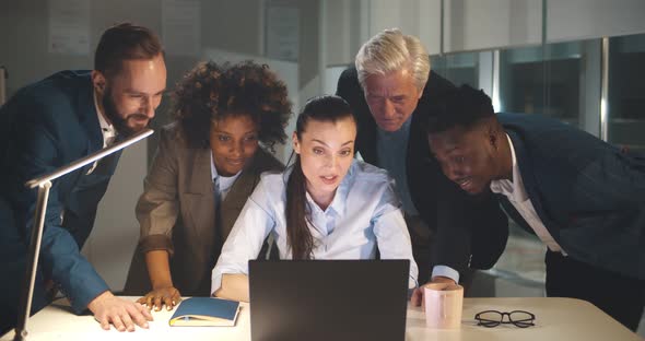 Diverse Businesspeople Working on Project Together in Office in Evening alt