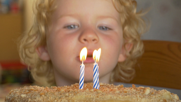 Three Year Old Boy Blowing Off The Candles