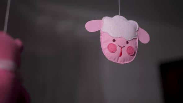 Baby Mobile with Pink Handstitched Animal and Bird Toys with Yellow Moon on White Wall Background alt