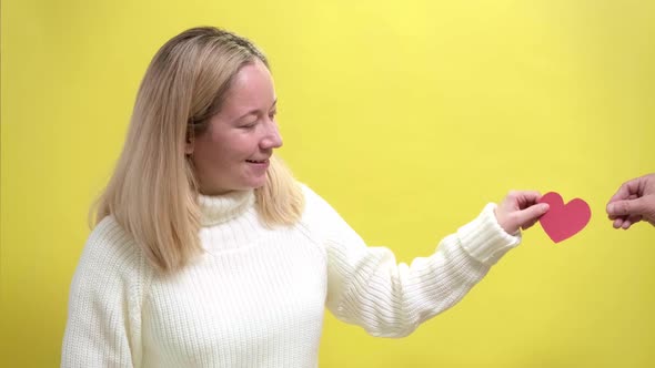 Blond Girl Accepting a Gift in the Form of Paper Heart alt