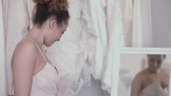 Young bride admiring herself in wedding dress