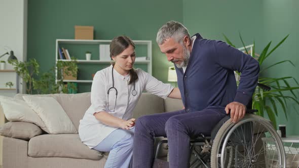 A Caring Nurse Assists a Middleaged Man in a Wheelchair at Home alt