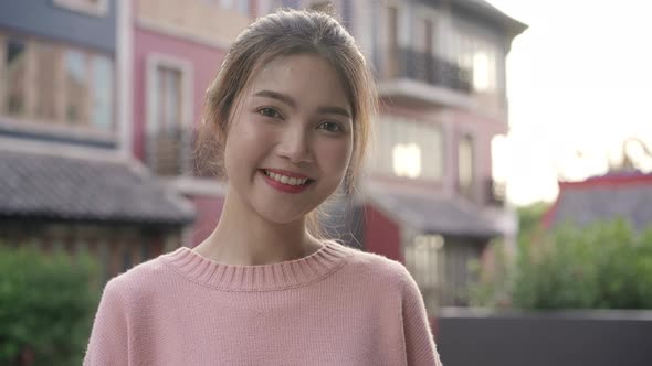 Asian woman feeling happy smiling to camera while traveling at Chinatown in Beijing, China. alt