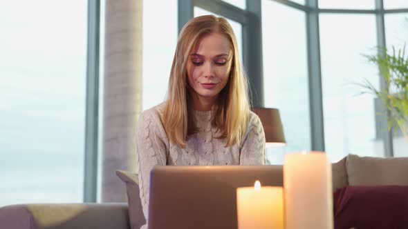 Attractive Woman Resting on Couch and Using Laptop alt