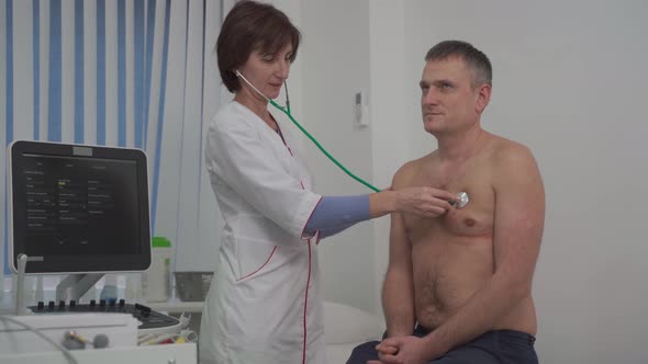Caring Caucasian Female Doctor Use Phonendoscope Examine Male Patient Heart Rate at Consultation in alt