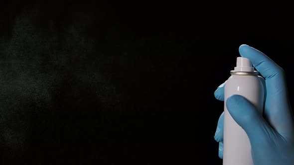 Spraying Disinfectant Aerosol Spray on a Black Background. Disinfectant for the Prevention of Colds alt