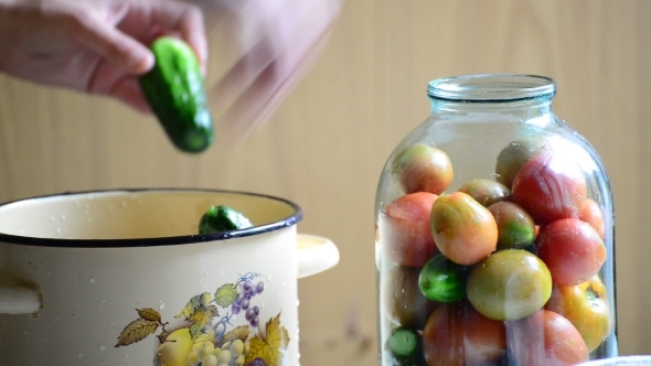 Woman Lays Tomatoes And Cucumbers In Jars Home