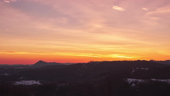 Pastel Sky with Slow Moving Clouds at Dusk Over Forest Landscape in Spring alt