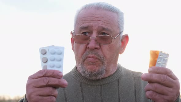 Gray Sick Grandfather with Pills in His Hands alt