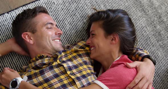Cute couple relaxing together on floor mat in living room at home 