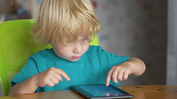 Portrait Of Cute Little Boy Using Digital Tablet