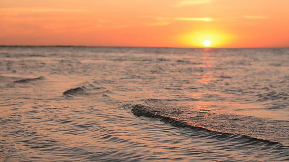 Flat Sea Surface With Small Waves at Sunset
