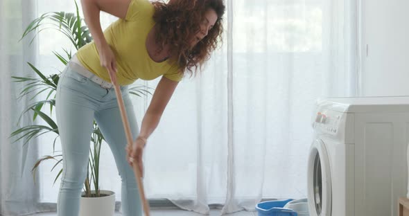 Washing machine leaking and woman cleaning