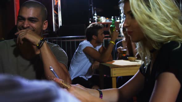 Group of friends toasting beer mugs at a concert 4k alt