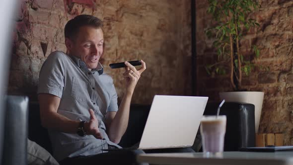 Guy Talking On Mobile Phone And Taking Notes Using Voice Assistant Writing In Notebook alt