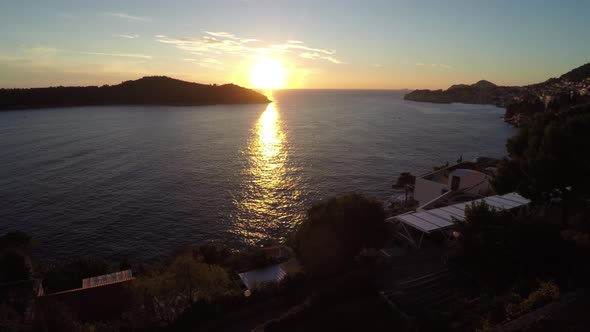 Aerial view of buildings on the coast at sunset alt