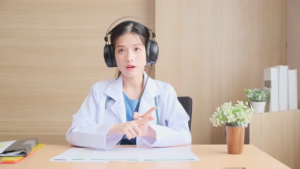 Young attractive Asian female doctor diagnosis talking and looking to camera alt