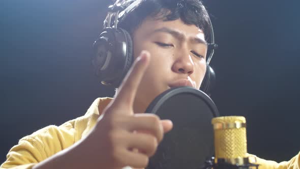 Young Asian Boy With Headphone Rapping Into A Condenser Microphone On ...