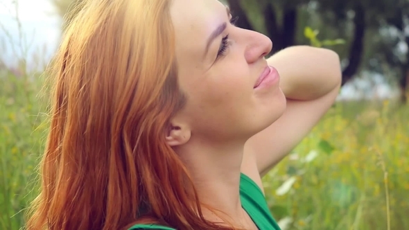 Romantic Red-haired Young Woman In Green Smiles