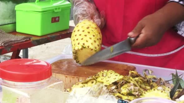 Woman Cutting Pineapple